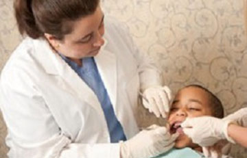 Dental Hygienist inspecting a boy's mouth